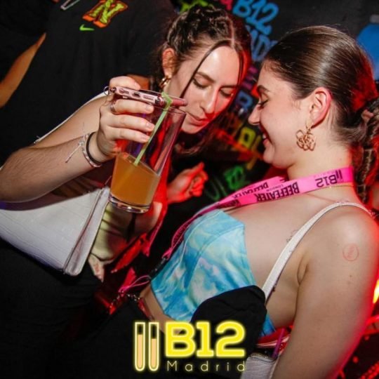 Interior de B12 con dos chicas con copas en la mano